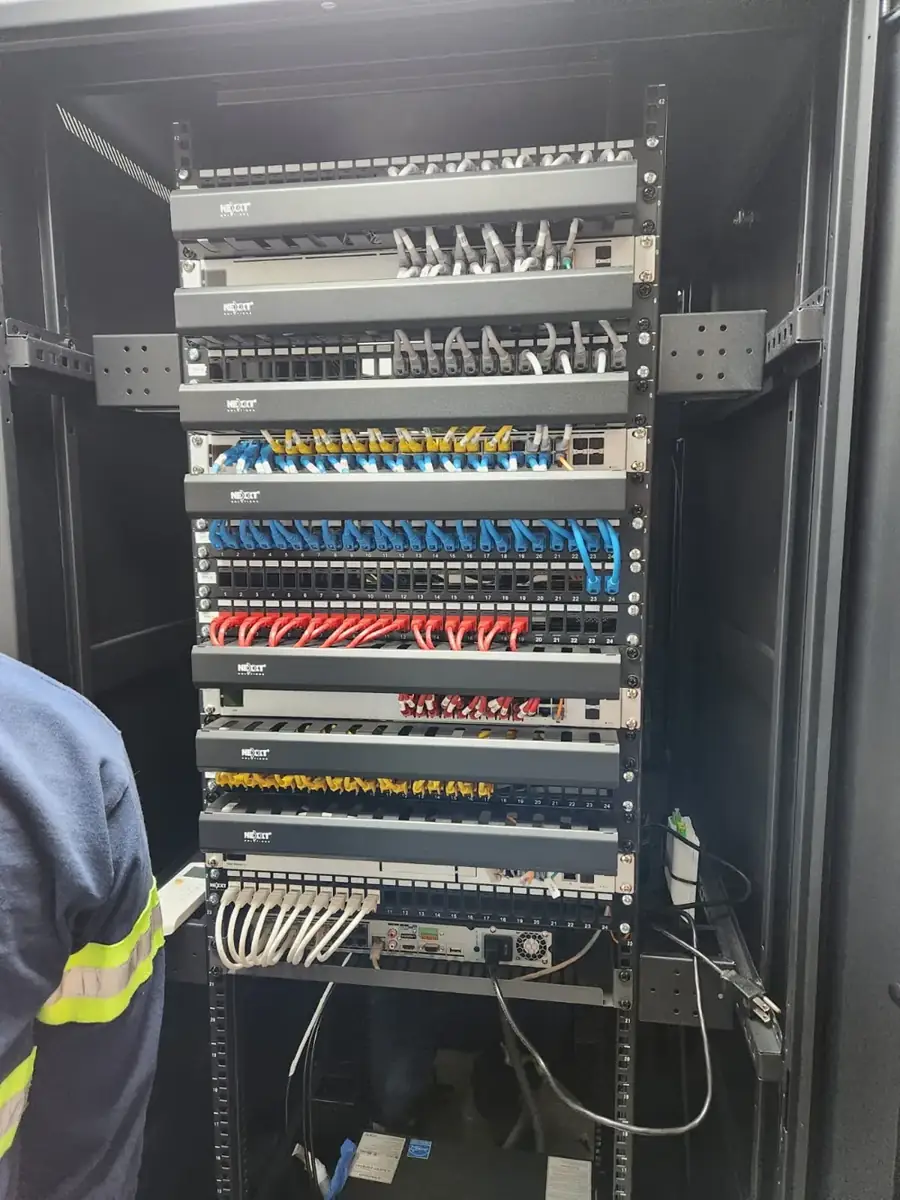 Rack de cableado estructurado con patch panels y cables de red organizados